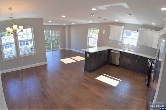 kitchen featuring dark hardwood / wood-style flooring, backsplash, stainless steel appliances, pendant lighting, and white cabinets