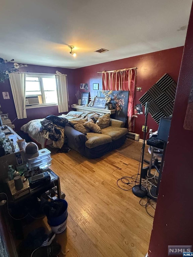 bedroom featuring wood-type flooring and cooling unit