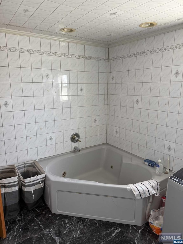 bathroom featuring a bath and tile walls