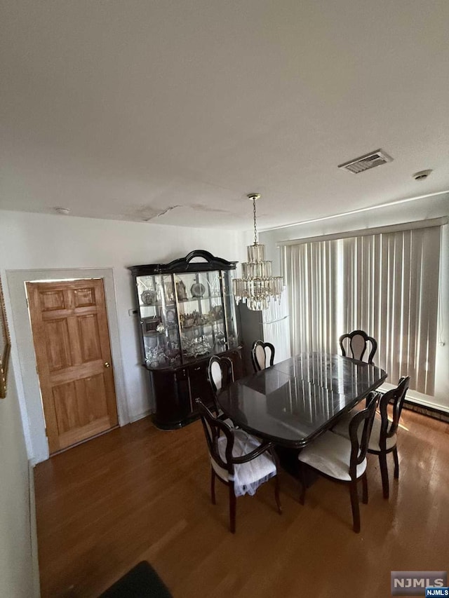 dining space with an inviting chandelier and hardwood / wood-style flooring