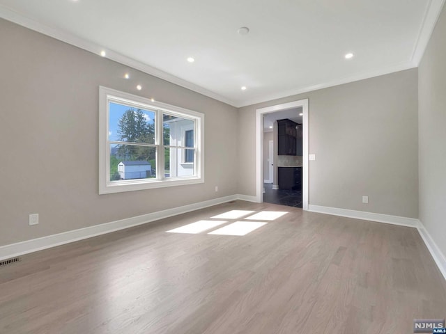 unfurnished room featuring wood-type flooring and crown molding