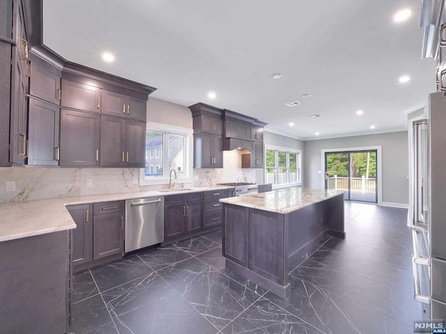 kitchen with tasteful backsplash, dark brown cabinetry, stainless steel appliances, sink, and a kitchen island