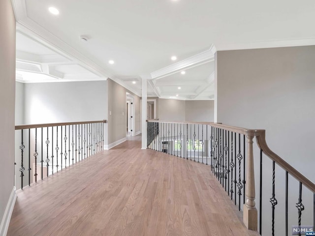 hall featuring beam ceiling, ornamental molding, coffered ceiling, and light wood-type flooring