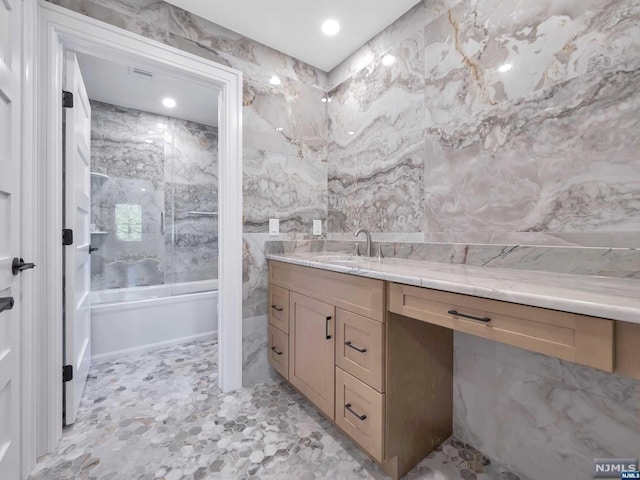 bathroom with vanity and tile walls