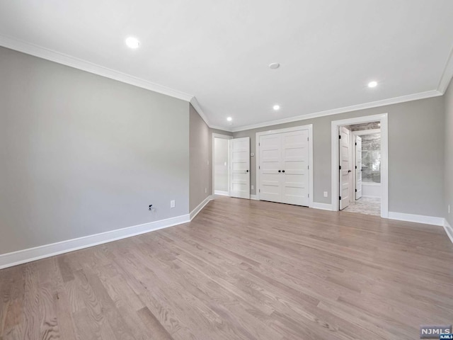 spare room with light hardwood / wood-style floors and crown molding