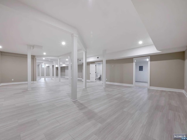 basement with light hardwood / wood-style flooring