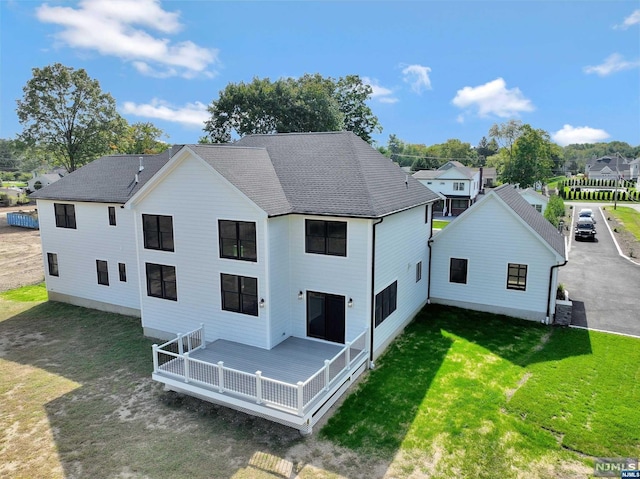 back of house with a lawn, a wooden deck, and central AC