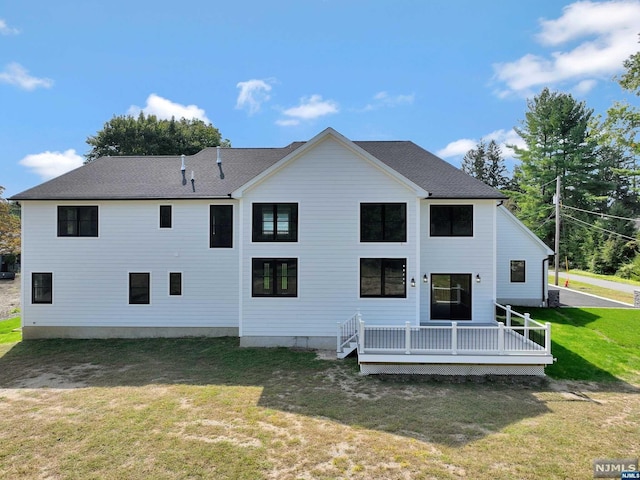 rear view of property with a deck and a lawn