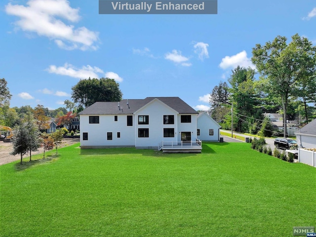 rear view of property with a yard and a deck