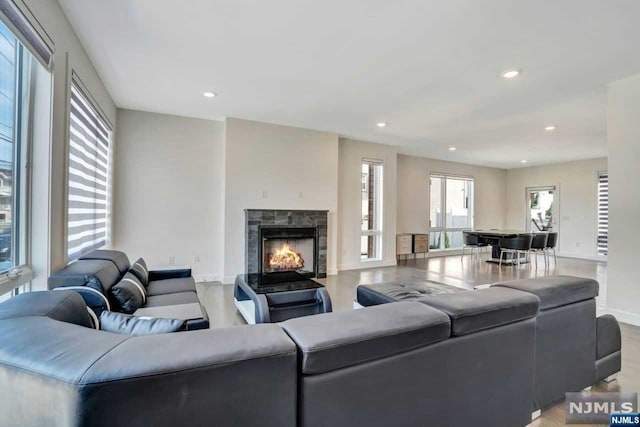 living room with a stone fireplace and light wood-type flooring