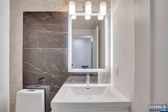 bathroom featuring backsplash, vanity, and tile walls