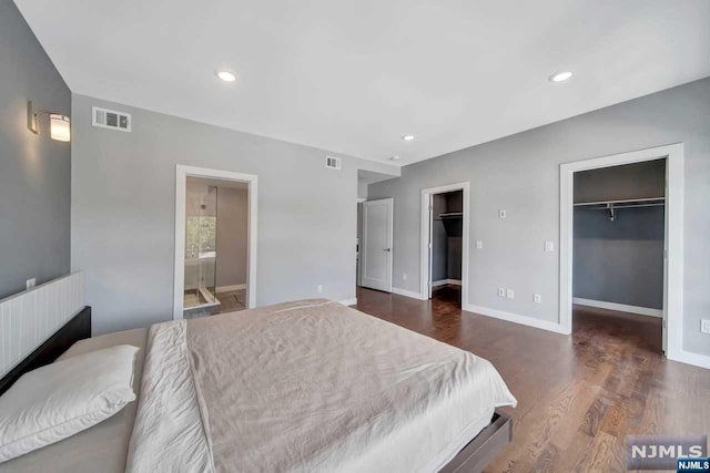 bedroom featuring a closet, ensuite bathroom, dark hardwood / wood-style flooring, and a spacious closet