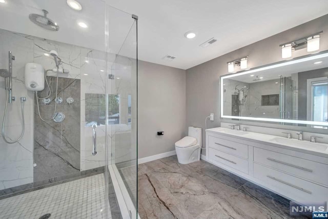 bathroom featuring a shower with door, vanity, and toilet