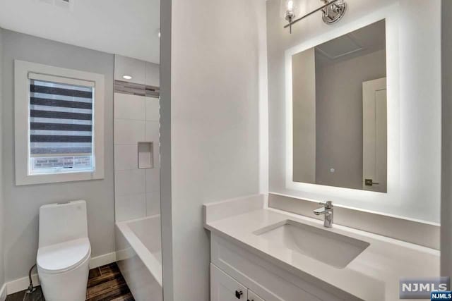 bathroom featuring vanity, wood-type flooring, and toilet