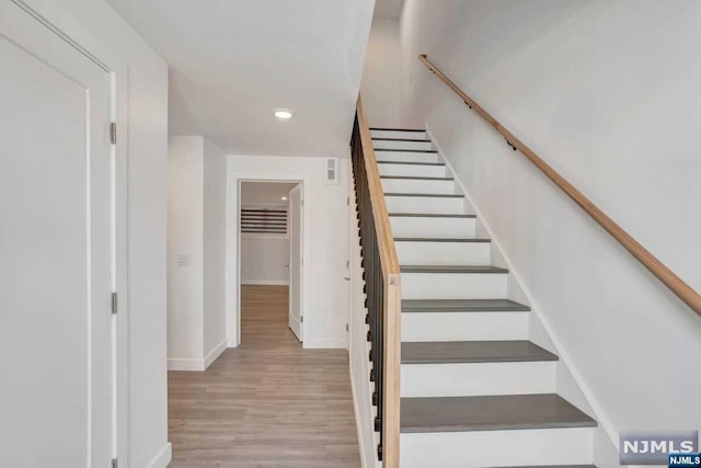 staircase with hardwood / wood-style flooring