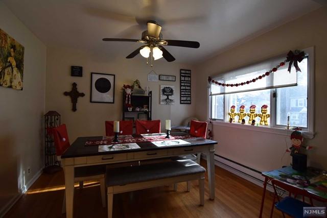 dining area featuring ceiling fan, a baseboard radiator, and hardwood / wood-style flooring