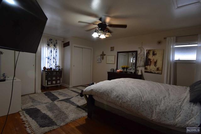 bedroom with a closet, hardwood / wood-style flooring, and ceiling fan