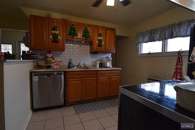 kitchen featuring backsplash, sink, stainless steel dishwasher, ceiling fan, and light tile patterned flooring