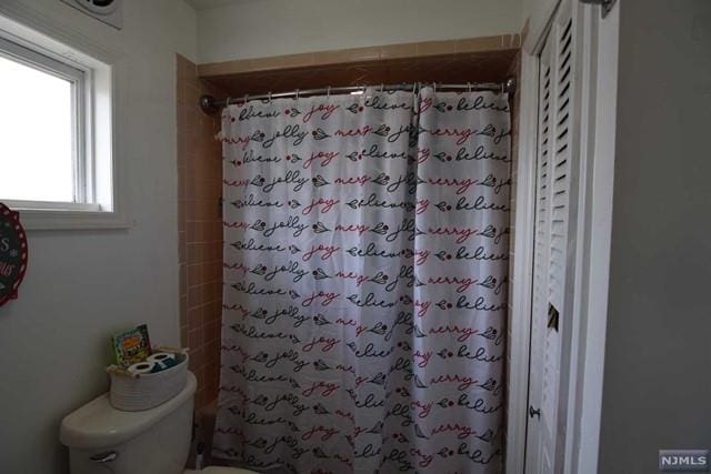 bathroom with curtained shower and toilet