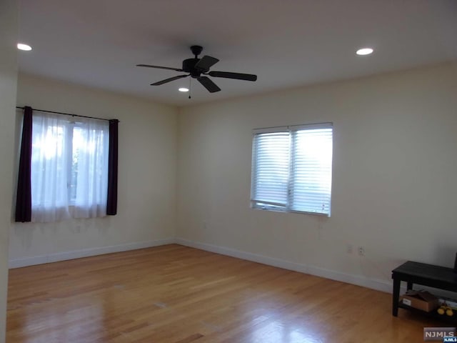 spare room with recessed lighting, wood finished floors, and baseboards