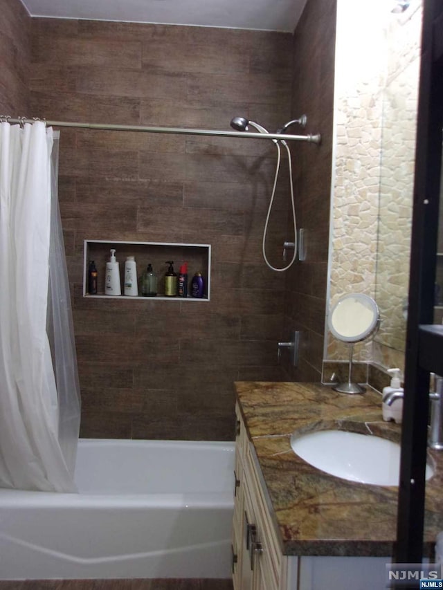 bathroom featuring vanity and shower / bathtub combination with curtain