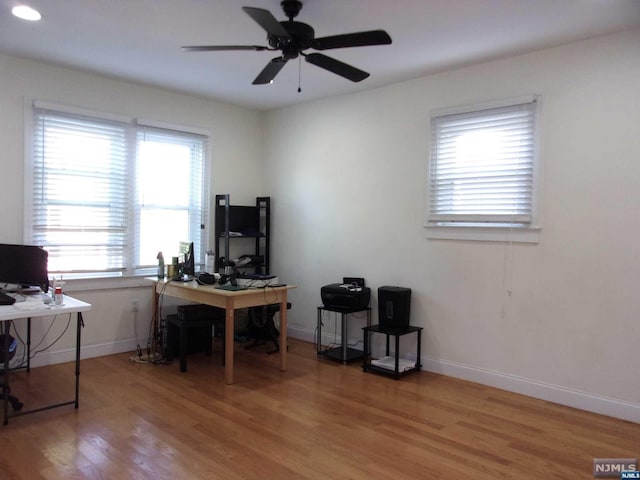 home office featuring baseboards, ceiling fan, and light wood-style floors