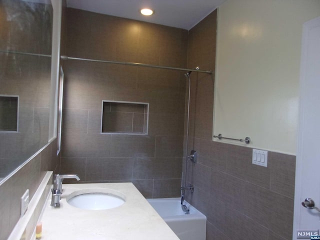 full bath with recessed lighting, shower / bath combination, tile walls, and vanity