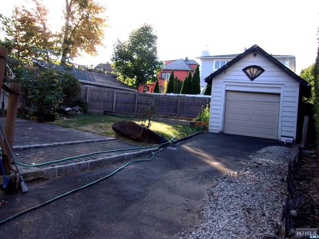 view of yard featuring a garage, fence, and an outdoor structure