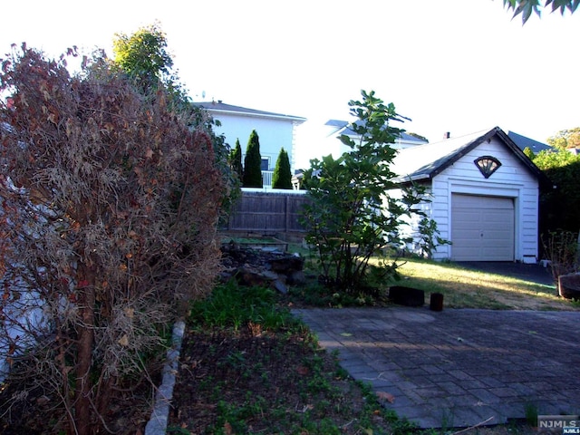 view of yard with a garage, an outdoor structure, and fence