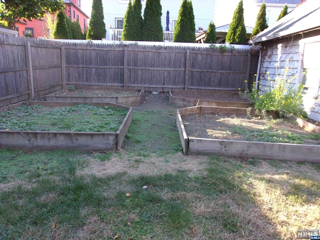 view of yard featuring a vegetable garden and fence