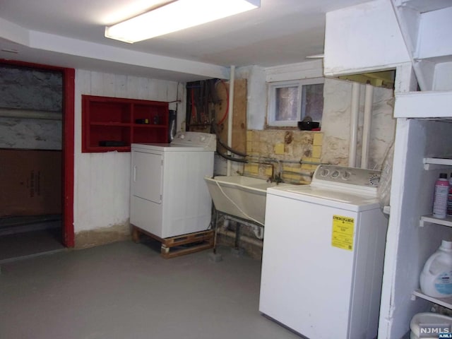 unfinished basement featuring a sink and washing machine and clothes dryer