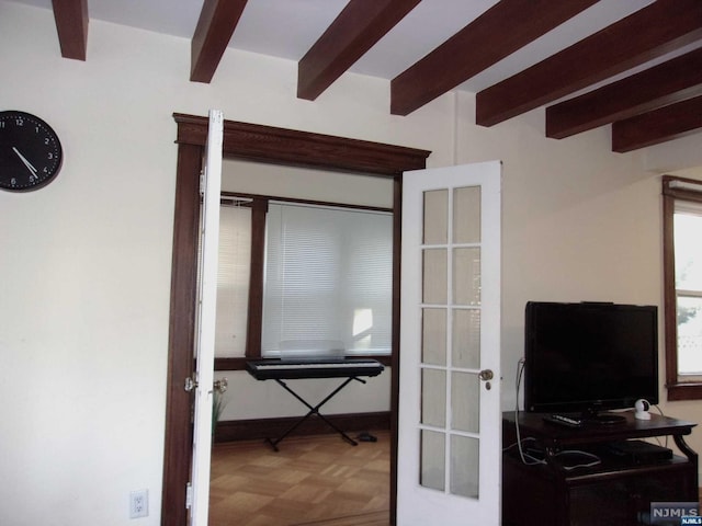 bedroom featuring beam ceiling and french doors