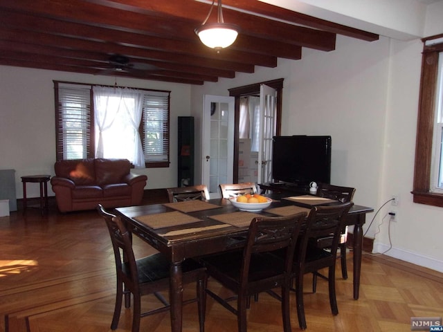 dining room featuring ceiling fan, baseboards, and beam ceiling