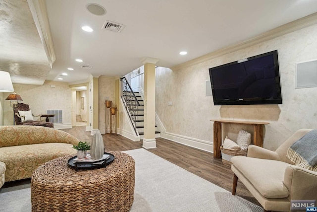 living room with wood-type flooring and crown molding