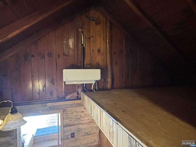 interior space featuring wooden walls, hardwood / wood-style floors, and lofted ceiling