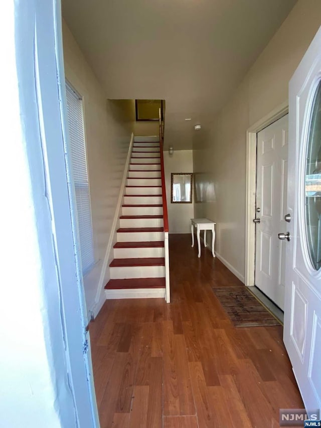 entryway with dark hardwood / wood-style flooring