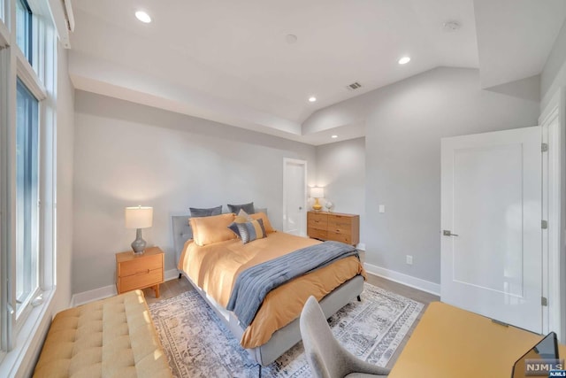 bedroom with light wood-type flooring and lofted ceiling