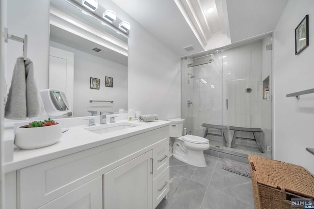 bathroom with vanity, toilet, and a shower with shower door