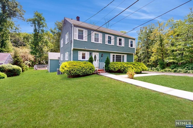 colonial-style house featuring a front yard