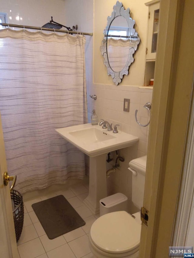 bathroom with tile patterned flooring, toilet, tile walls, and a shower with shower curtain