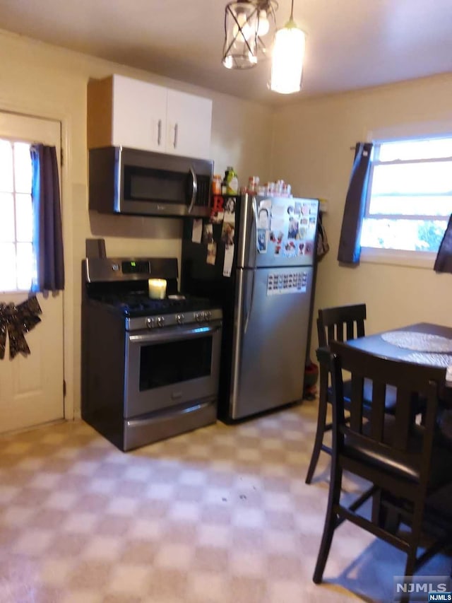 kitchen featuring plenty of natural light, white cabinets, and stainless steel appliances