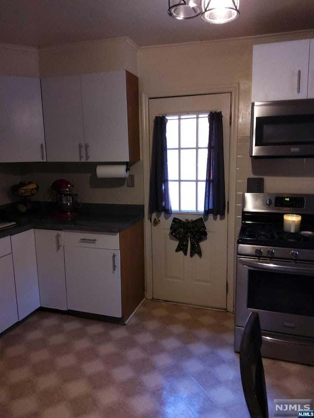 kitchen featuring decorative backsplash, white cabinetry, and stainless steel appliances