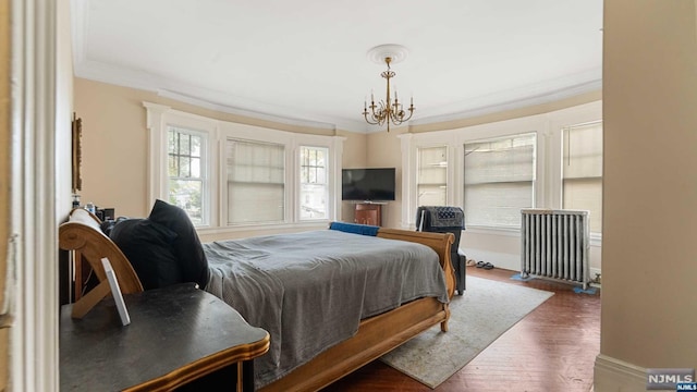 bedroom with radiator, crown molding, dark hardwood / wood-style floors, and a notable chandelier