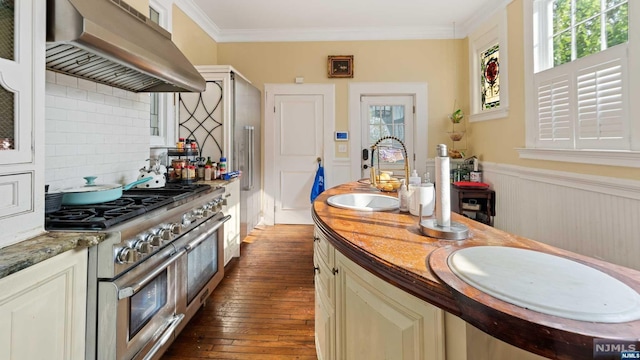 kitchen featuring range with two ovens, dark wood-type flooring, extractor fan, and a healthy amount of sunlight