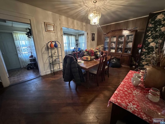 dining space with dark hardwood / wood-style flooring, a wealth of natural light, and a chandelier