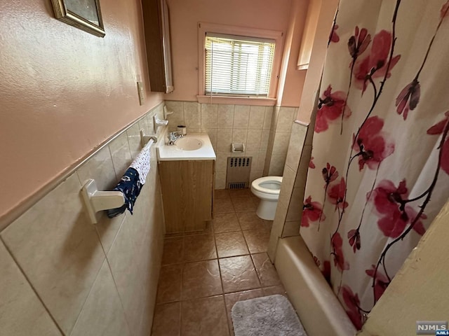 full bathroom with vanity, radiator, shower / bath combination with curtain, toilet, and tile walls