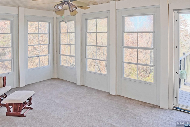 unfurnished sunroom featuring ceiling fan