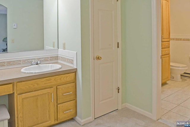 bathroom with toilet, vanity, and tile patterned floors