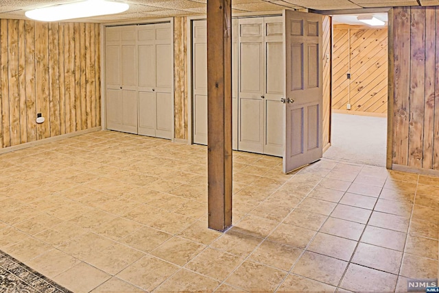 basement featuring wooden walls