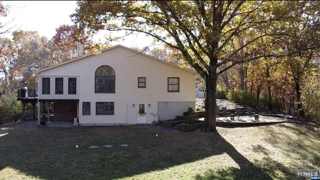 rear view of property featuring a yard and a patio